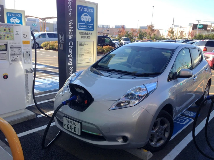 a plug in car charging on the street