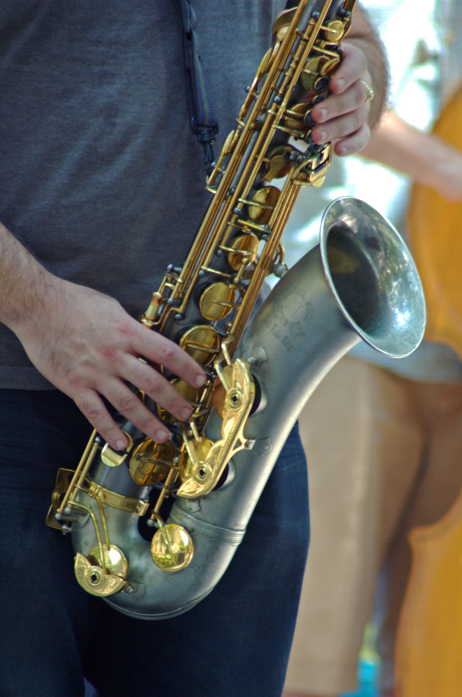 the person is playing on a saxophone outside