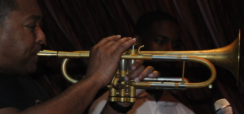 a person holds their instrument up to his ear