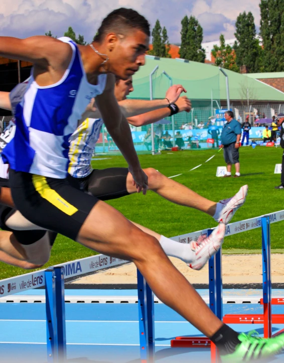two athletes race over the hurdles in competition