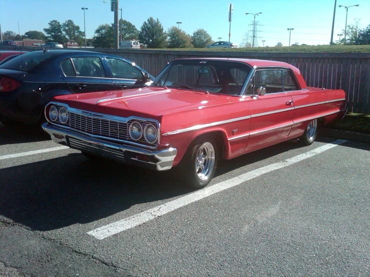 a red car is parked in the parking lot