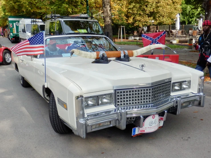 a vintage car with american flags on top