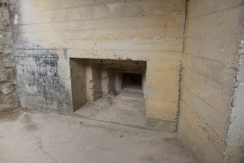 a small area with a cement wall, a hole and cement floor