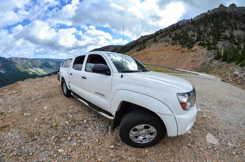 a white pick up truck parked on a rocky hill