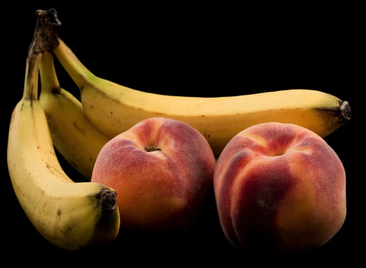 three peaches and two bananas are side by side
