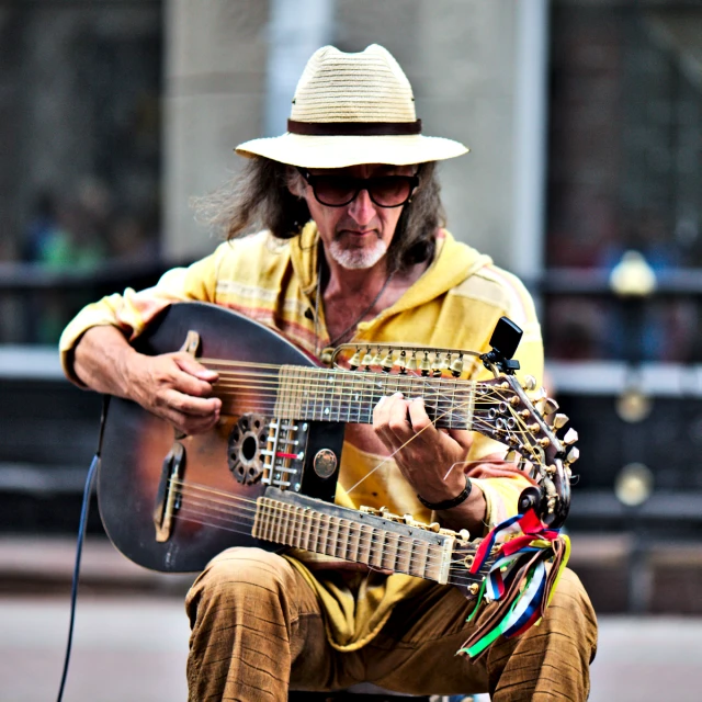 man with large hat playing music on an electric guitar