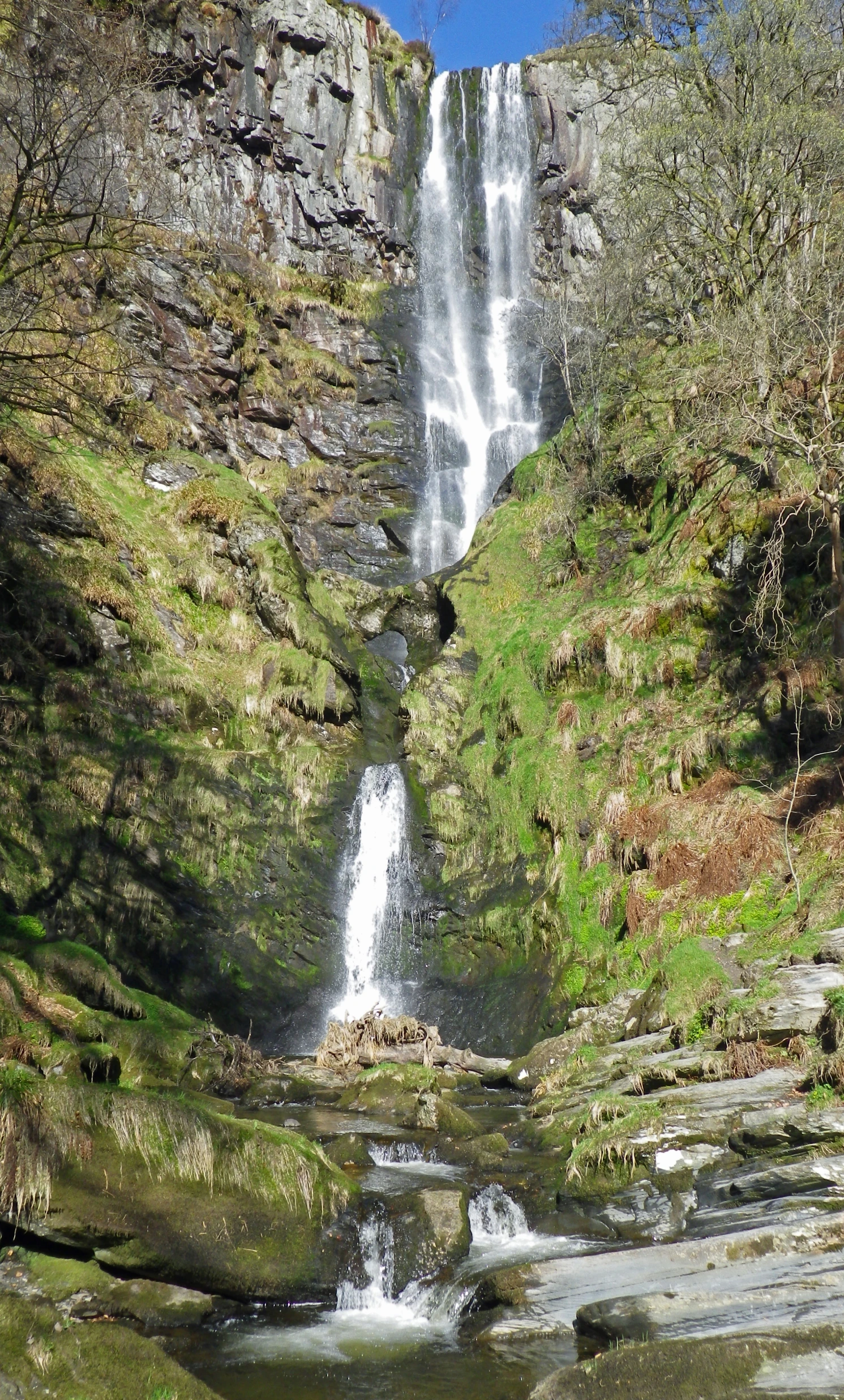 a waterfall on the side of a rocky hill