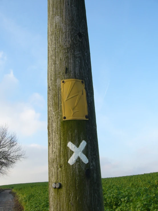 a mailbox attached to a wooden pole by a road