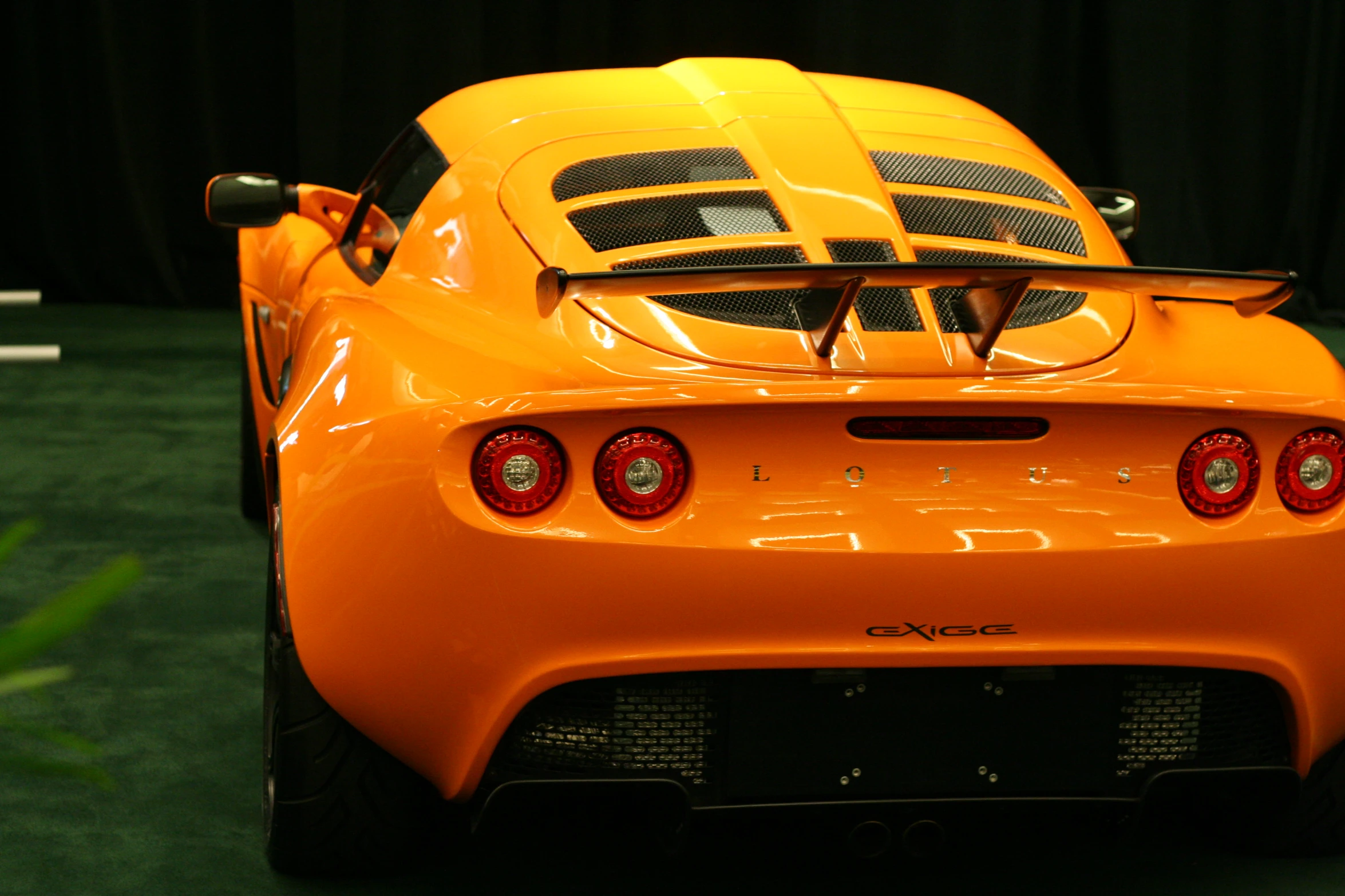 an orange sport car with no hood is seen from behind