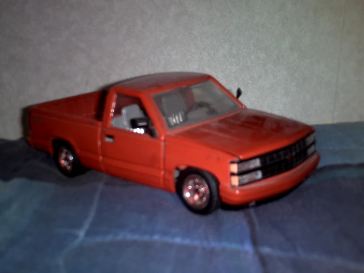 toy pickup truck on a bed of a room