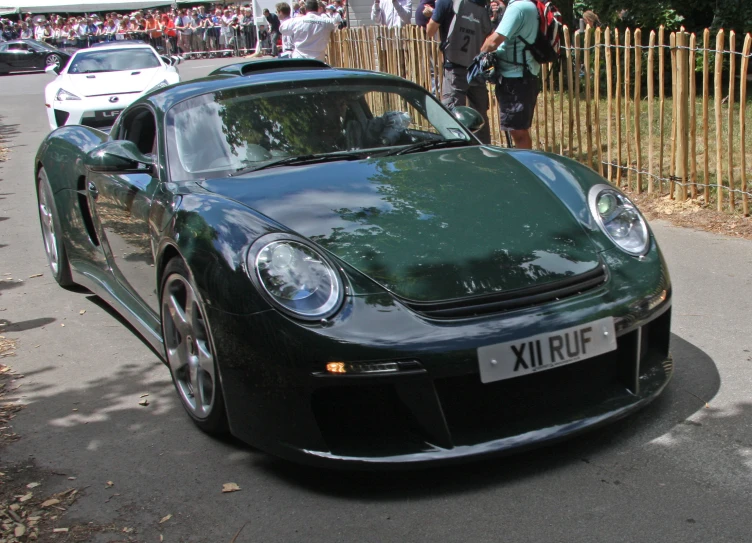 a black sports car on a street next to other cars