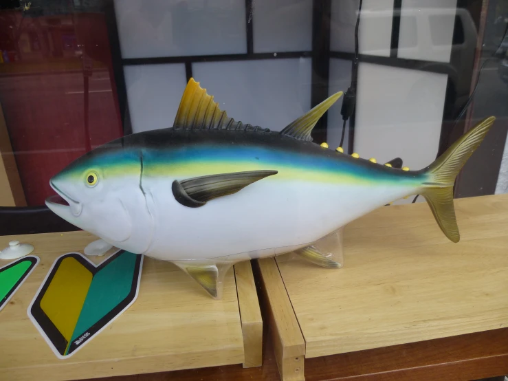 a colorful stuffed fish on display in a store window