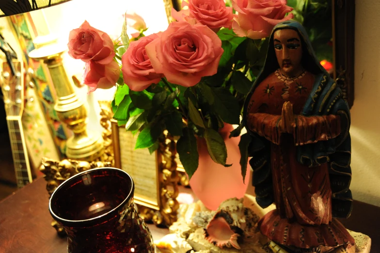 a decorative vase with roses and a statue in front