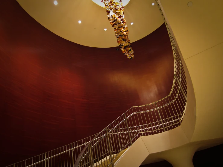 a curved staircase in a big building with wooden walls and lights