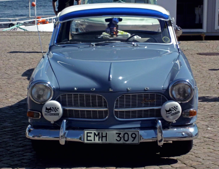 an old classic car with a surfboard on top