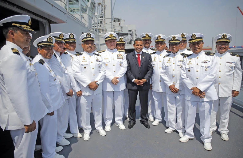 many navy sailors are standing in a row with president obama