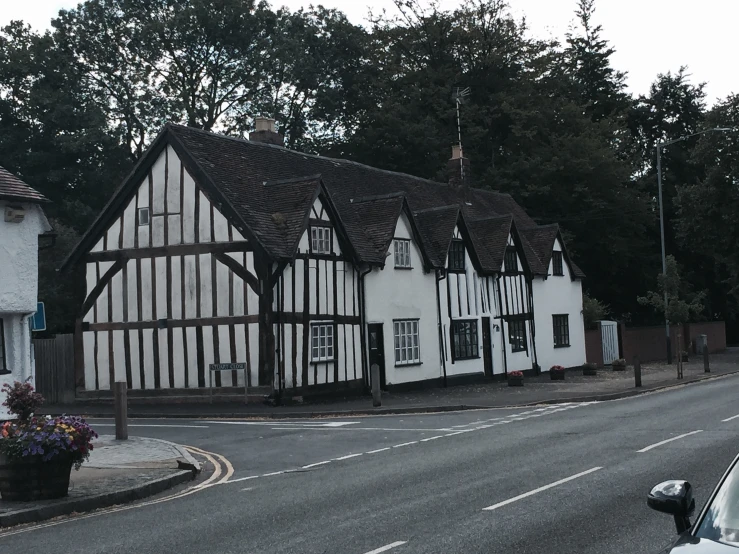 a white and black building with flowers in front