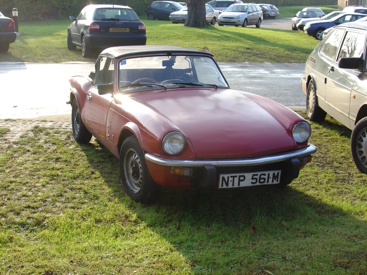 a red sports car is parked in a field