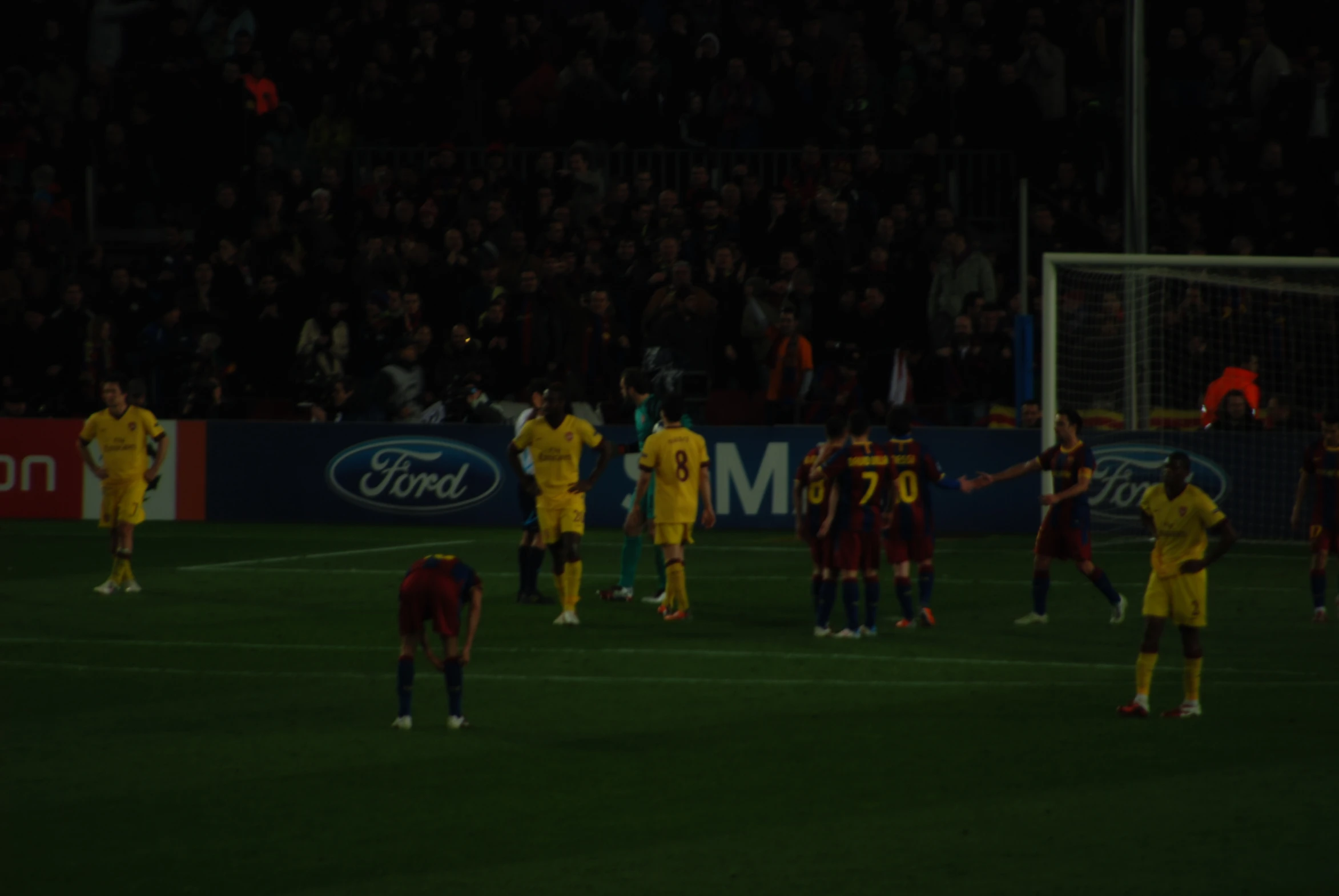 a team of soccer players stand on the field as fans stand by to take a po