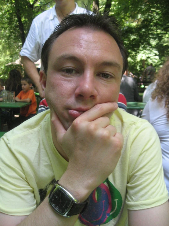 a man sitting on top of a table near a tree