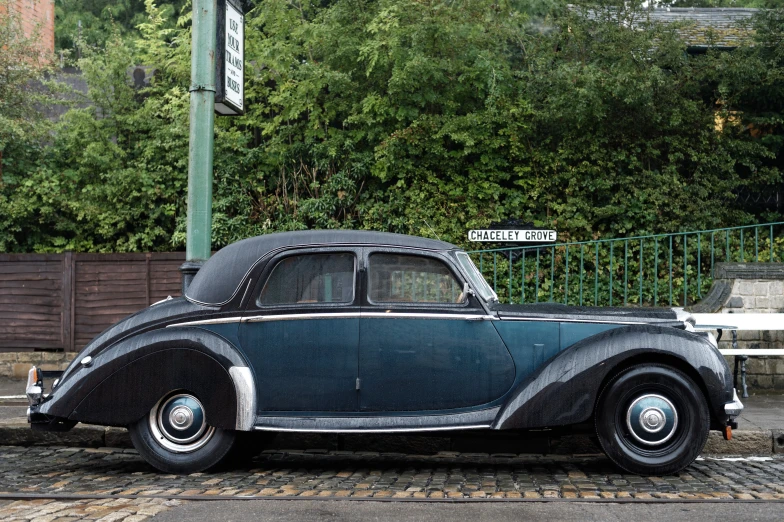 a car is parked at an empty intersection in a rainy day