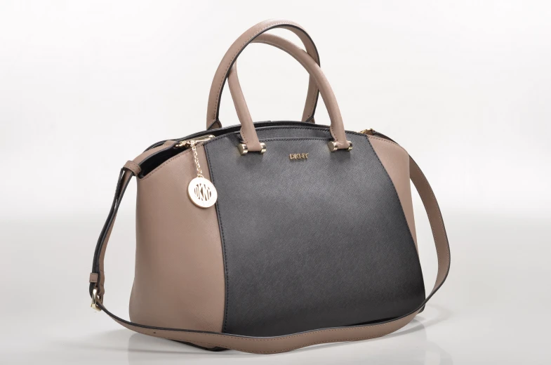 a grey and black handbag is sitting upright