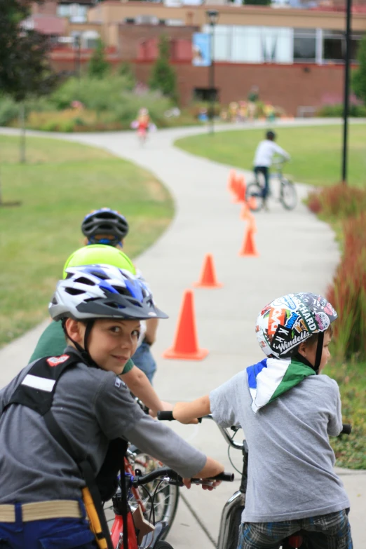 several children on bicycles on a path in the park