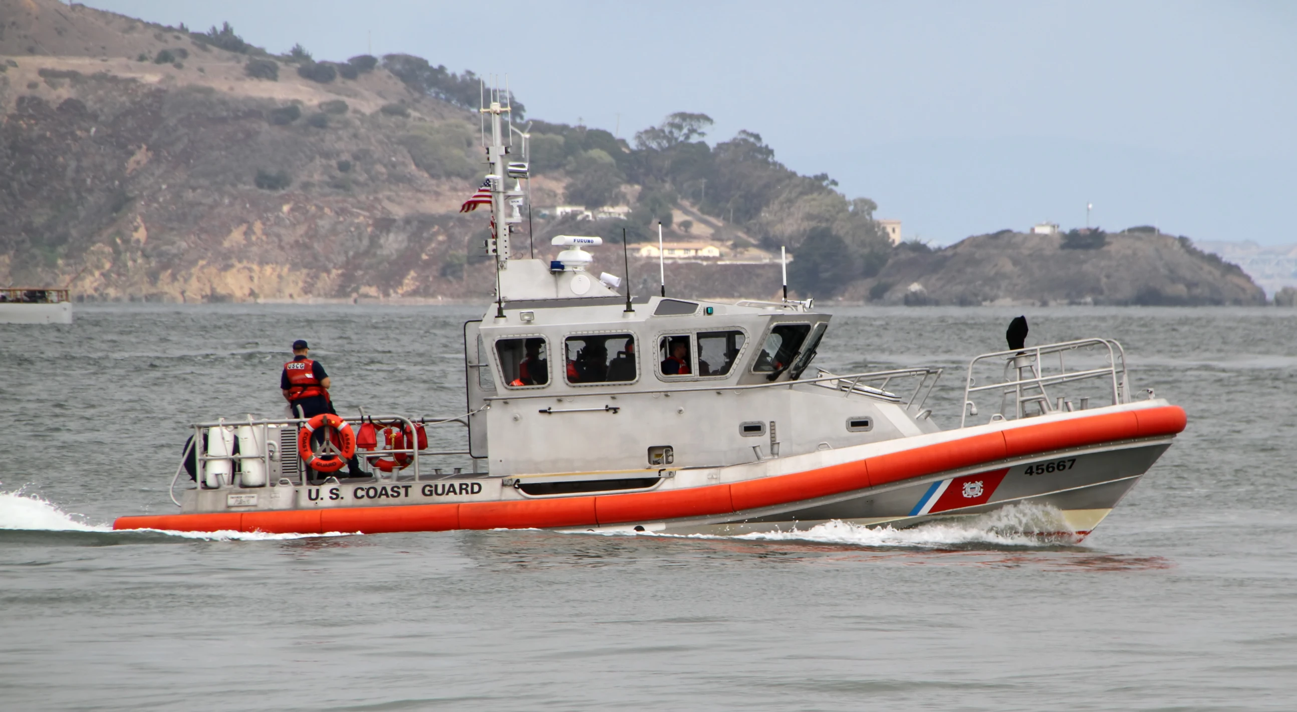 a small boat with a man standing on it's deck