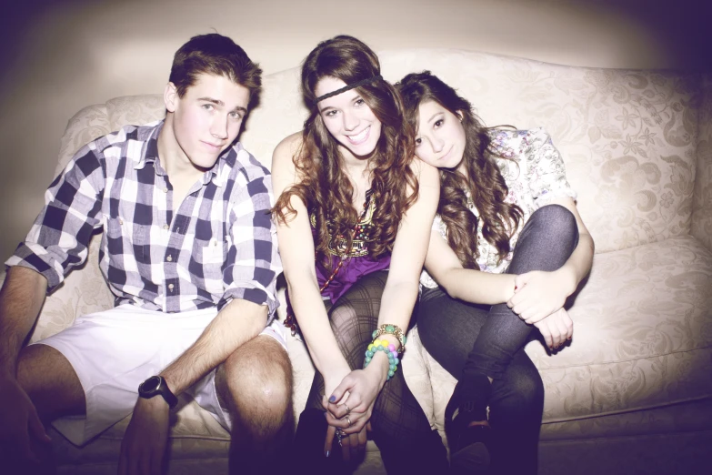 three young friends are smiling on the couch