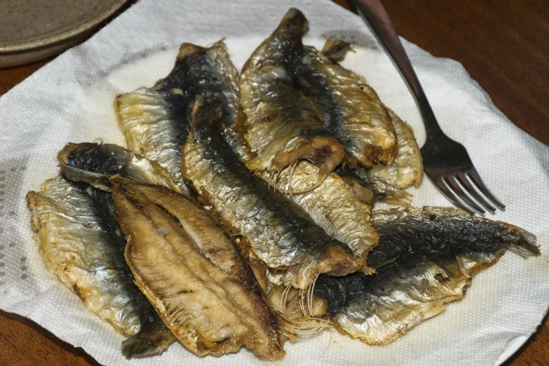 a plate full of fried fish and a fork