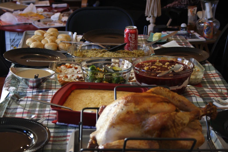 a table full of food is shown with bread, wine, salads and condiments