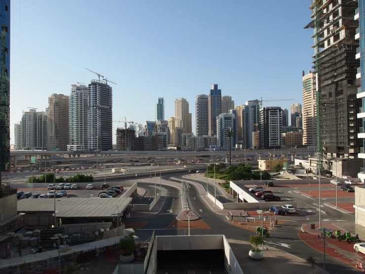 many vehicles move along a highway in front of some very tall buildings