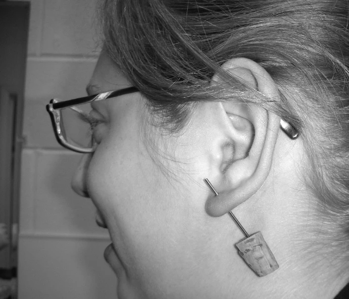 a person wearing an ear piercing device