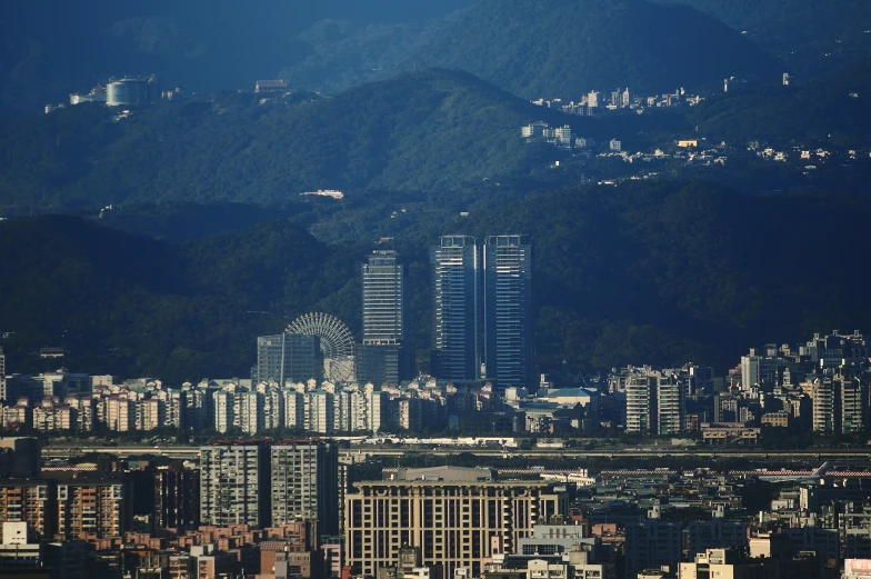 tall buildings stand amid the mountains in the city