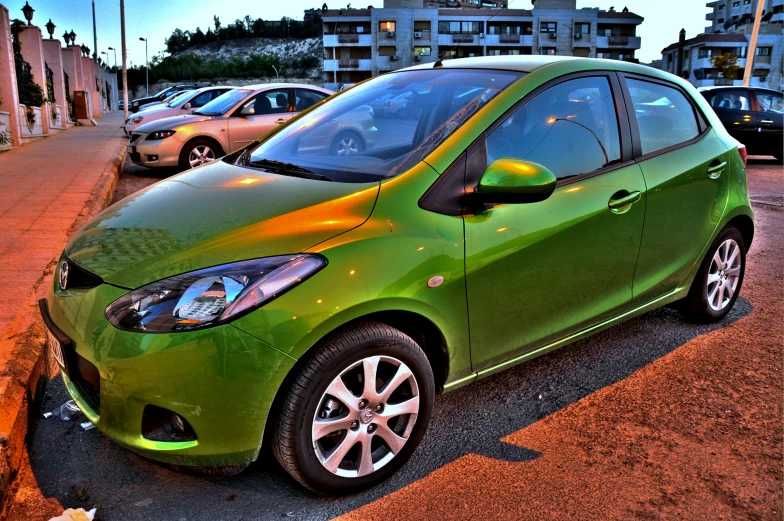 a small green car is parked in the street