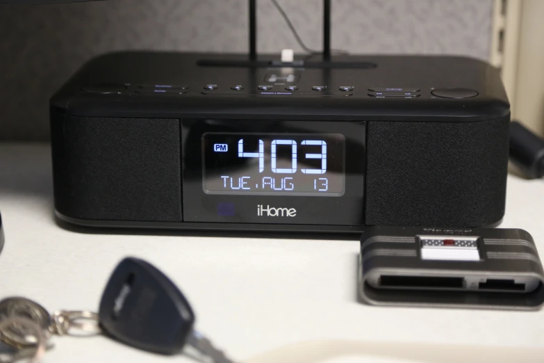 an alarm clock on the counter next to a key