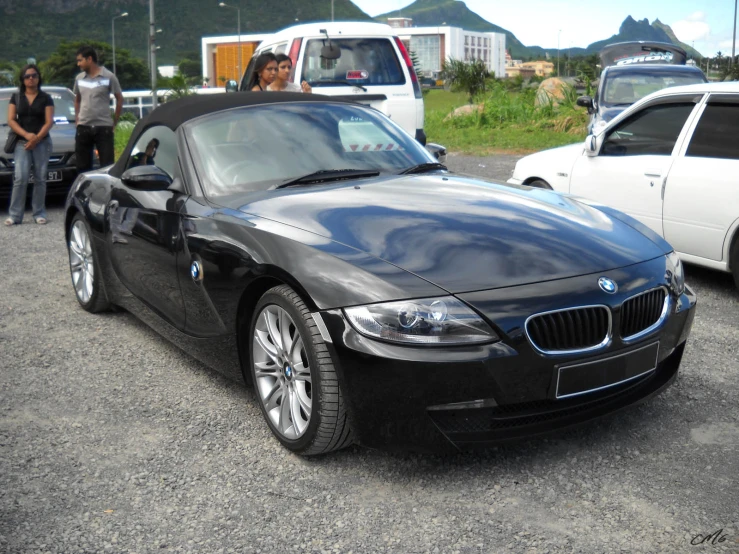 an extremely shiny bmw convertible sits parked with others behind it