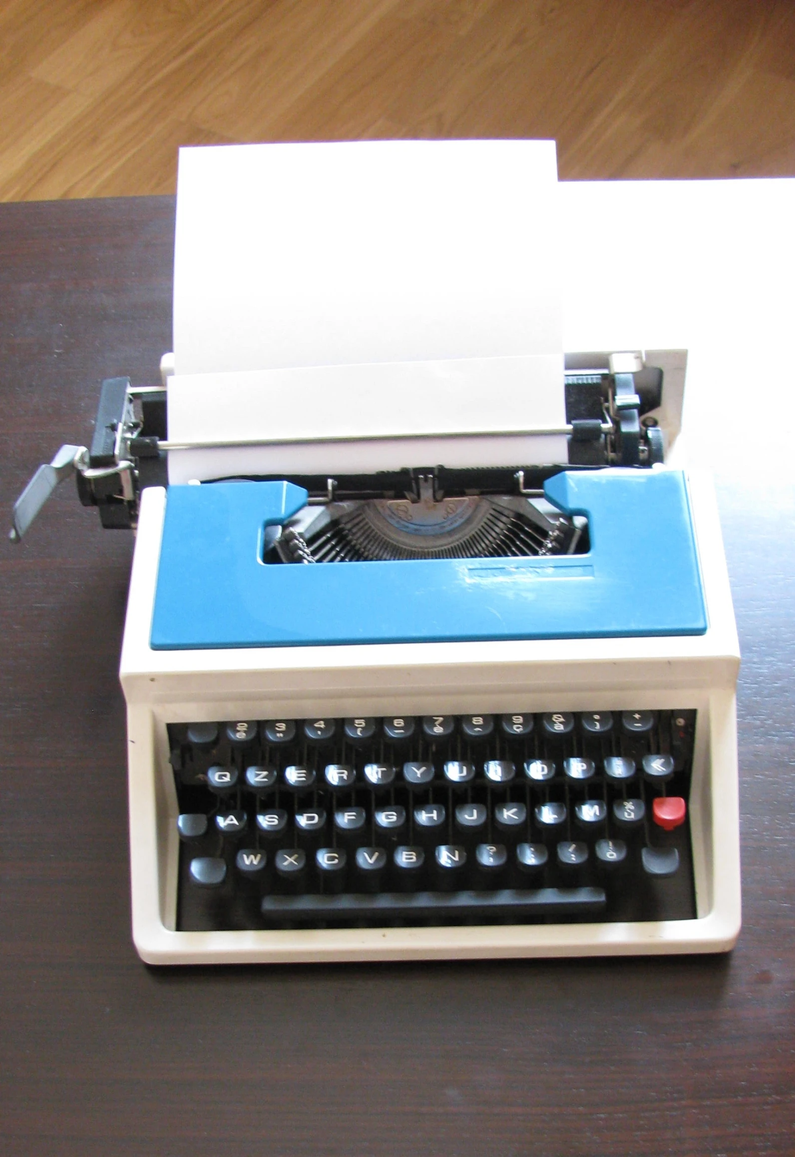 an old fashioned white and blue typewriter is shown