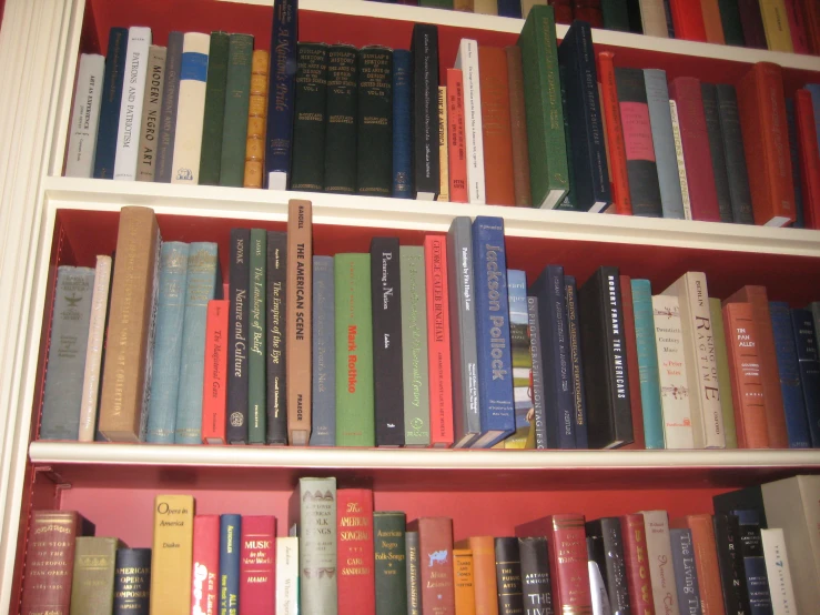 several rows of books sitting on top of a white book case