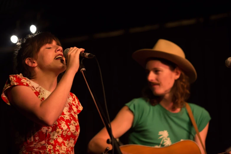 two people that are standing up and singing