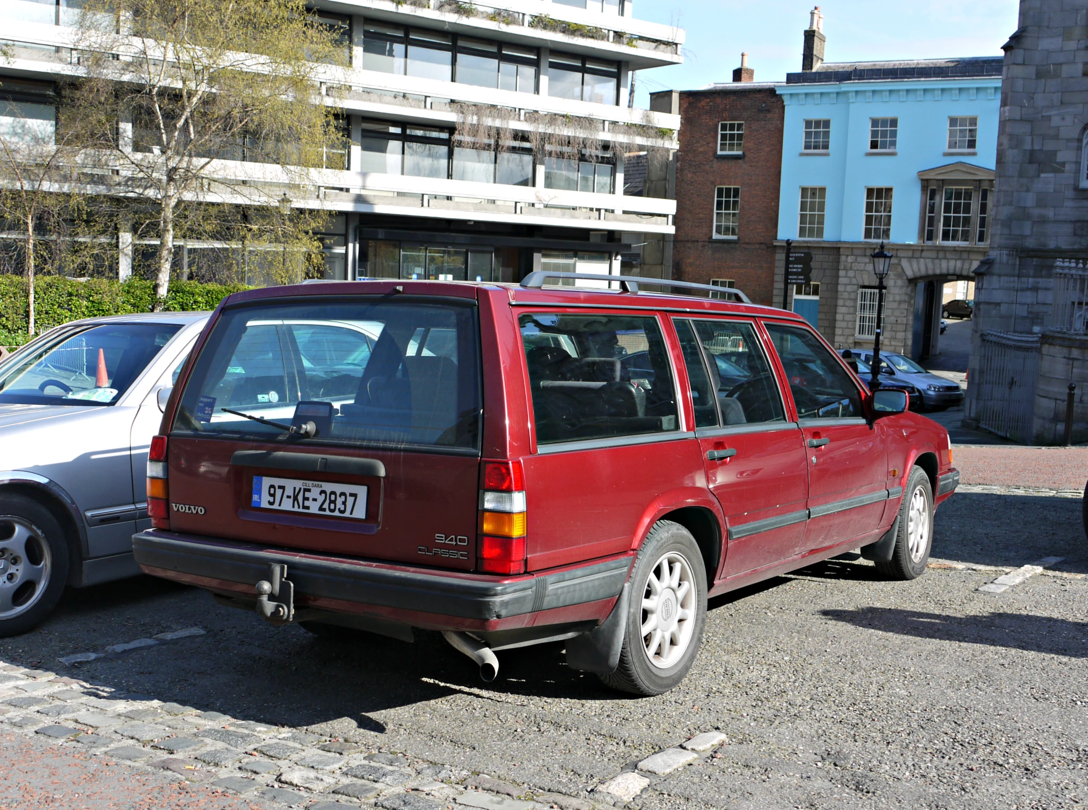 a car parked in front of another one with other cars