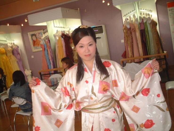 asian woman dressed in a kimono standing at a clothing store