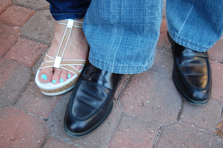 woman with blue nail polishes in her shoes and her feet in black leather shoes