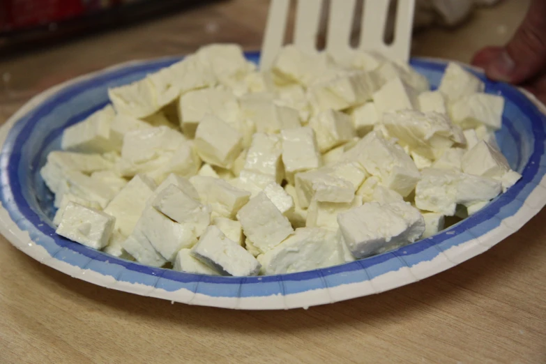 a blue and white plate on top of a table filled with food