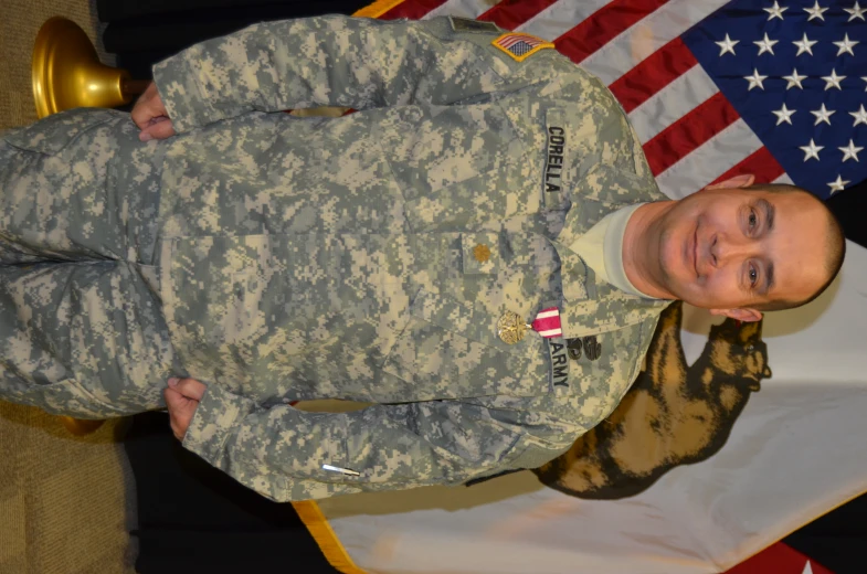 the soldier is posing in front of an american flag