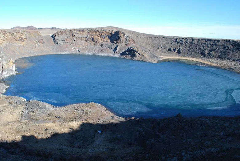 a large, icy body of water sits in an arid landscape