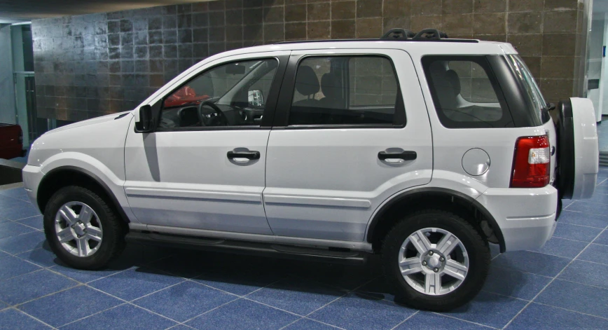 white suv in a building with door open