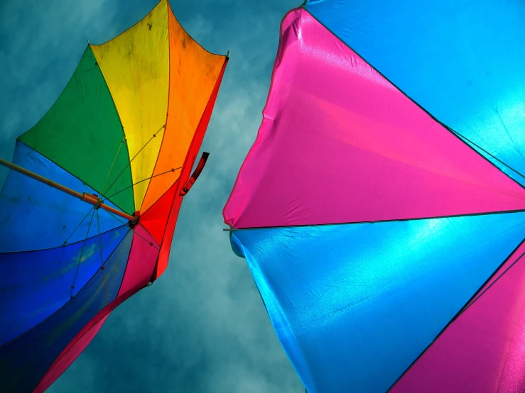 colorful umbrellas are flying on the cloudy sky