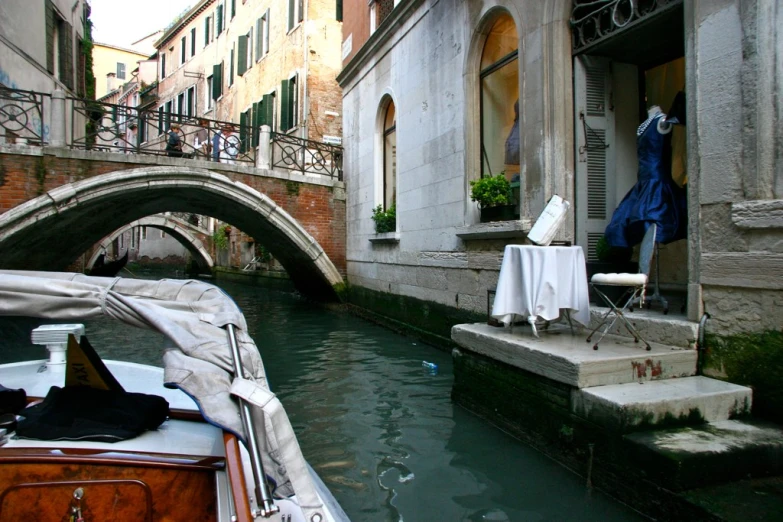 a couple of boats traveling past a bridge and a tall building