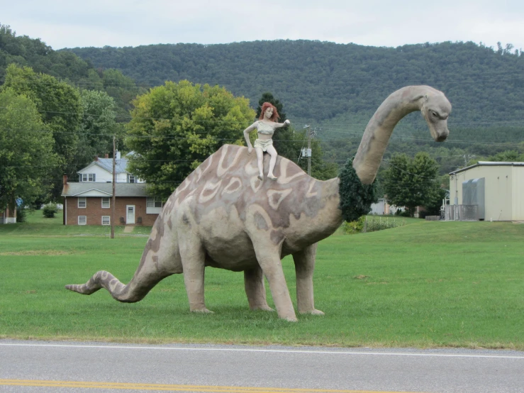 the woman is riding on the back of a dinosaur